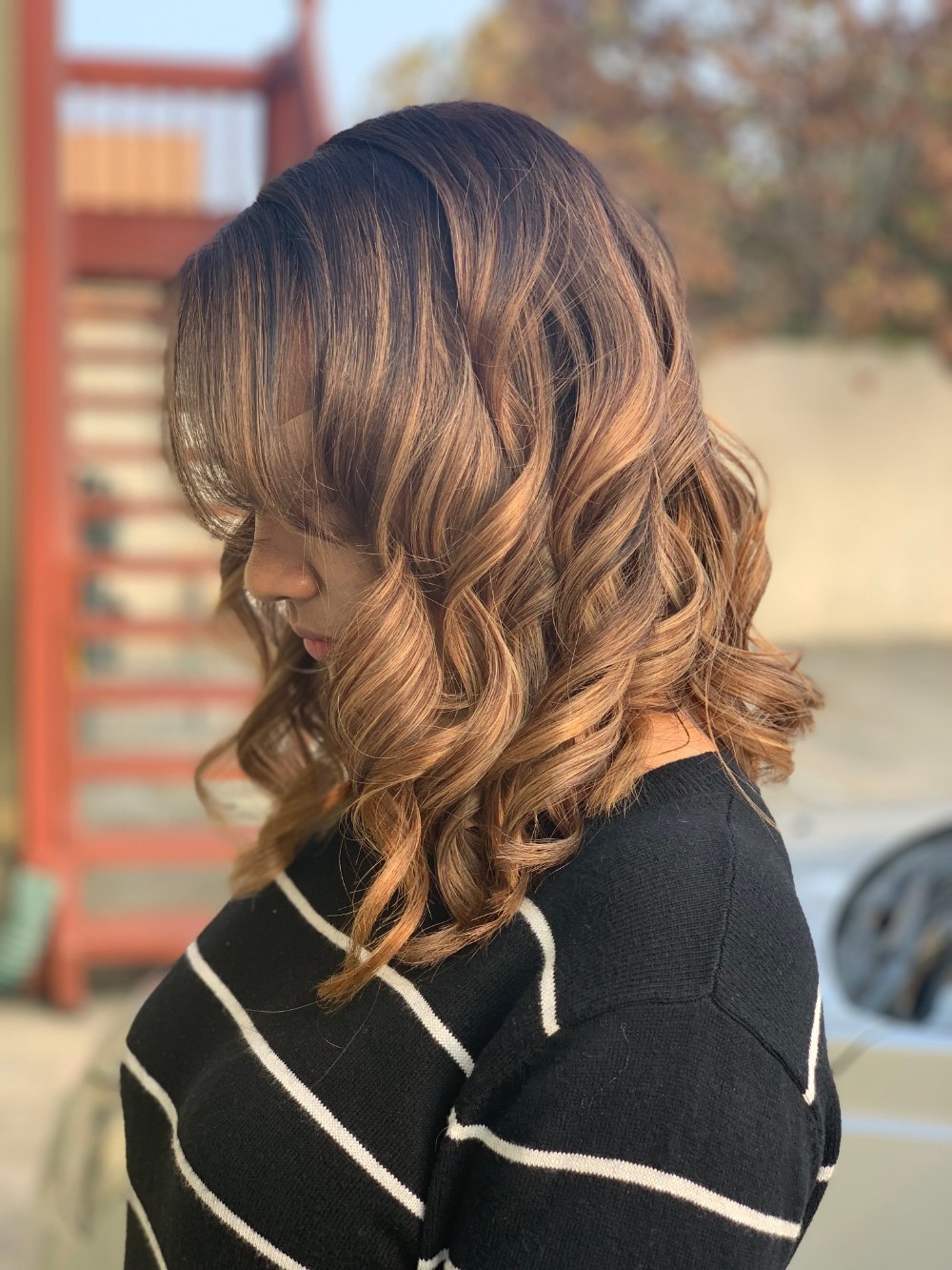 Color, cut and style: shoulder-length hair in warm copper and honey tones, finished in loose curls