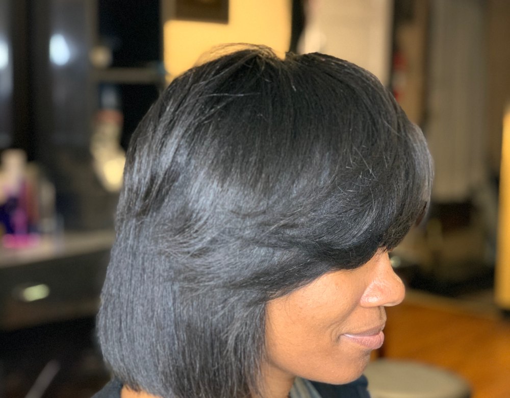 Side profile of a sleek, straight bob with side-swept bangs, a healthy hair care result