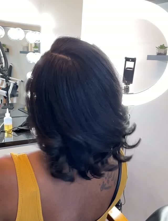 Back view of a shoulder-length silk press with curled ends