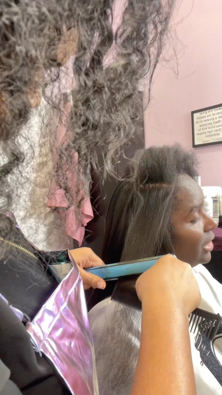 Silk press in progress: a flat iron passing through a section of hair at KodakStylez in Smyrna, GA