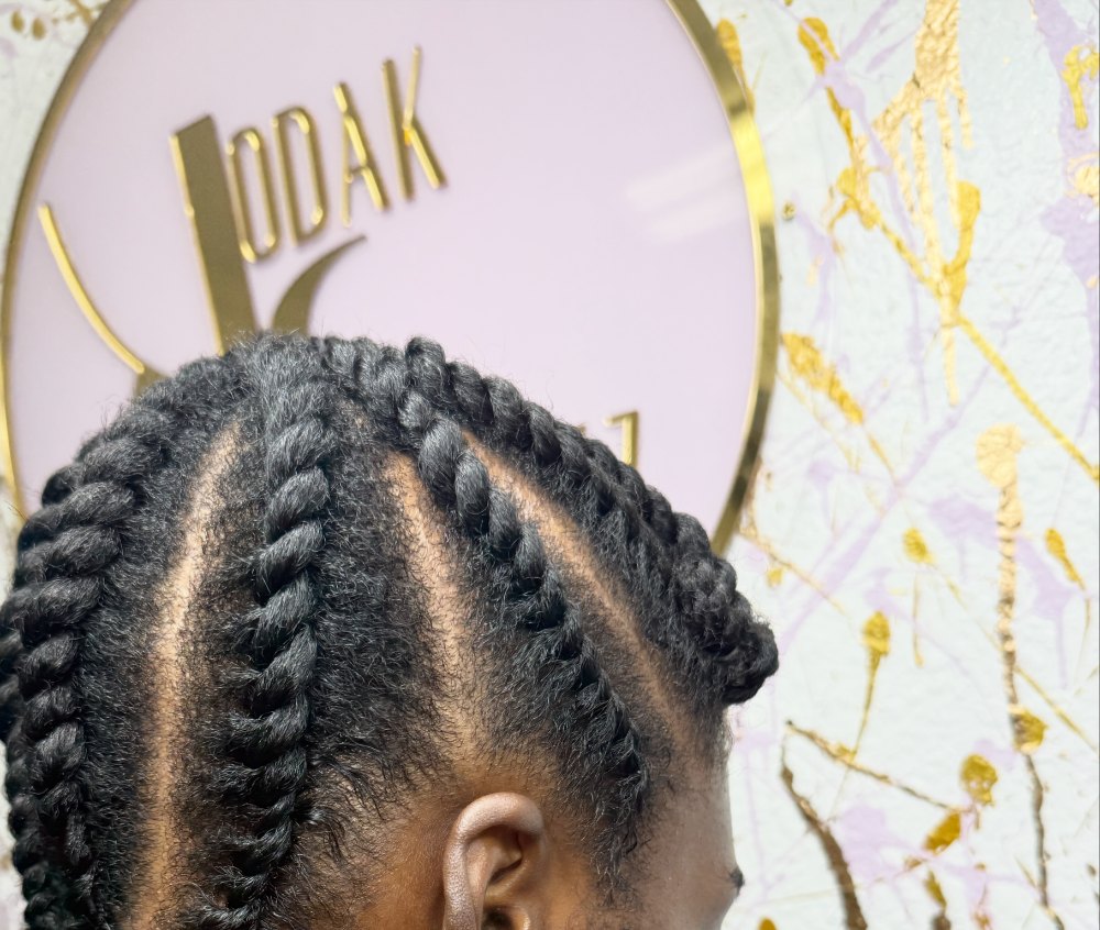 Twist to scalp: rows of flat twists on natural hair in front of the KodakStylez sign